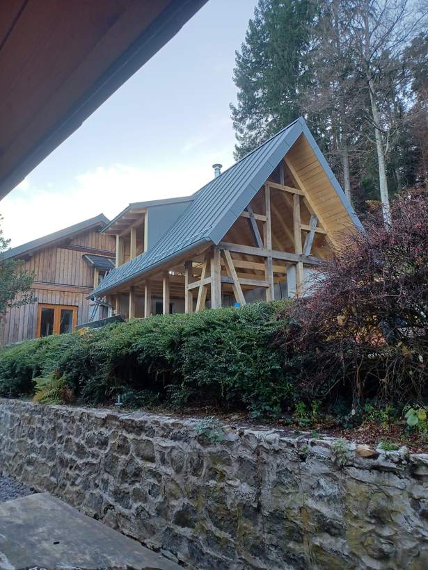 L’écurie en chantier : la charpente de bois neuve, ouverte sur la vallée
