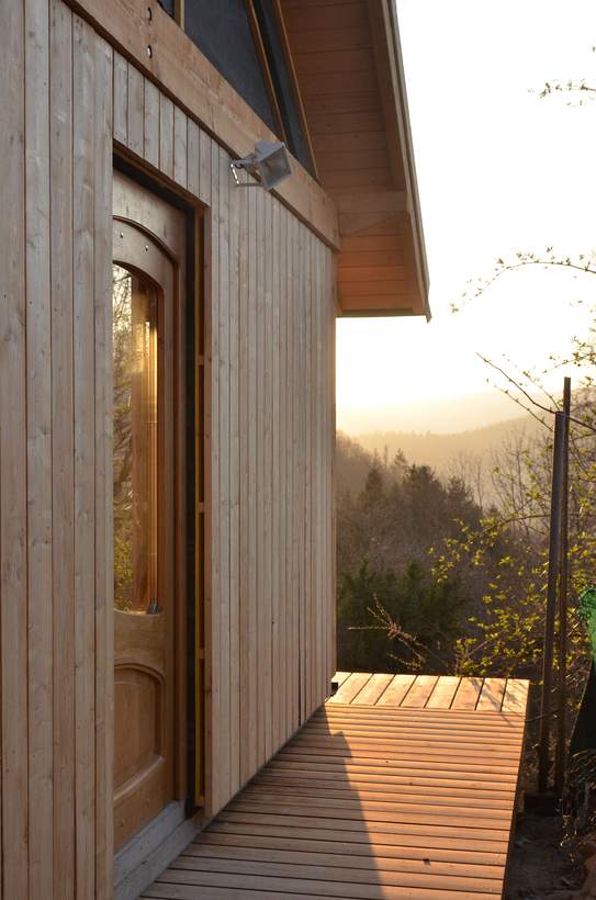 L’atelier au soleil couchant : la porte de chêne, la terrasse et la vue sur la vallée